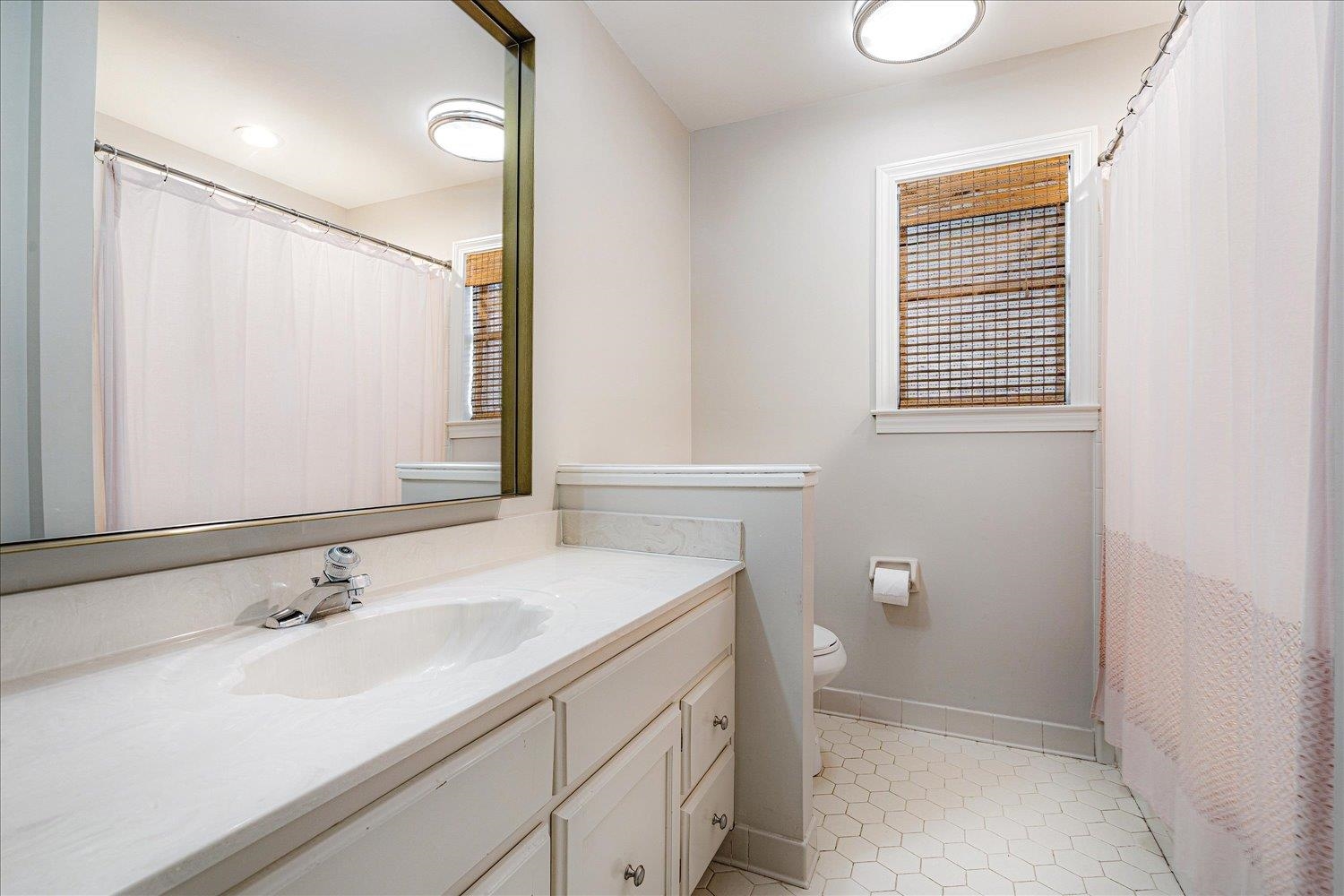 6677 Neshoba Road Memphis, TN 38120 - Photo 31 of 40 a bathroom with a sink a toilet and a mirror