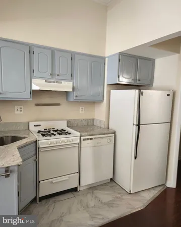a kitchen with a stove a refrigerator and a sink