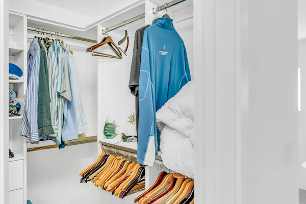 a view of walk in closet with clothes and shoes