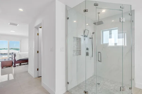 a bathroom with a glass shower door a sink and a shower