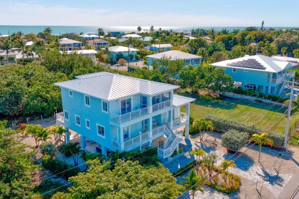 an aerial view of residential houses with outdoor space and parking