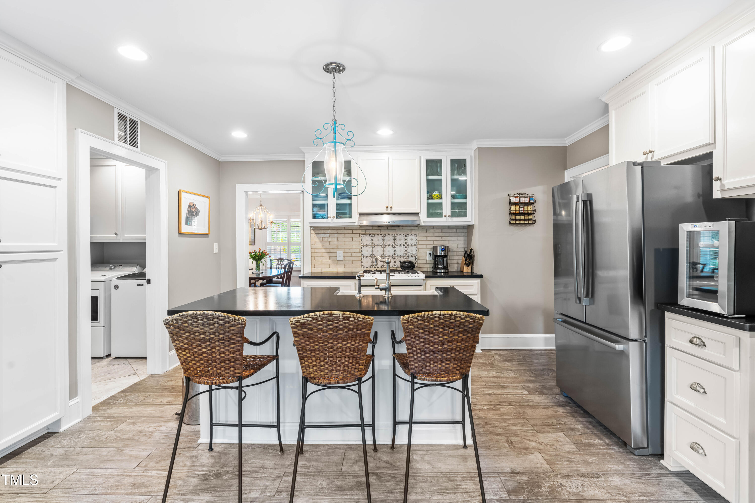 2725 Bedford Avenue Raleigh, NC 27607 - Photo 15 of 48 a kitchen with stainless steel appliances kitchen island granite countertop a refrigerator a stove a kitchen island with a dining table and chairs