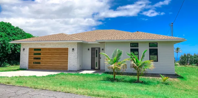 a front view of a house with a garden