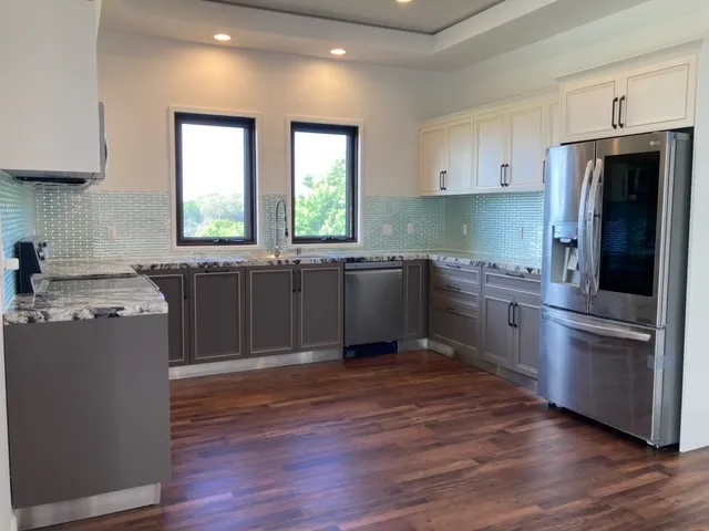 a kitchen with stainless steel appliances granite countertop a stove a sink and a refrigerator