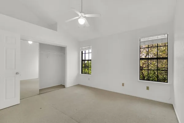 an empty room with windows and closet