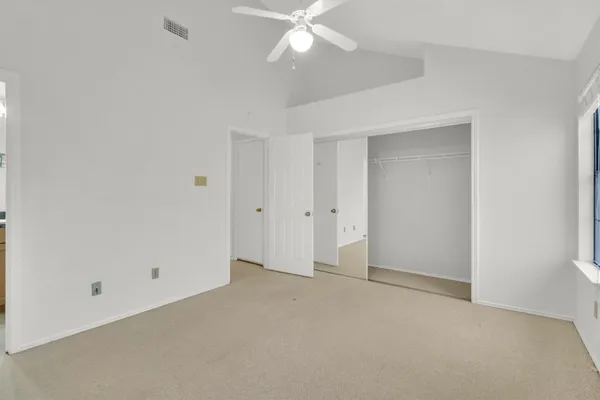 a view of an empty room with a ceiling fan