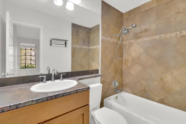 a bathroom with a granite countertop sink toilet and shower