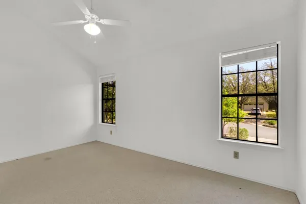 an empty room with a window and ceiling fan