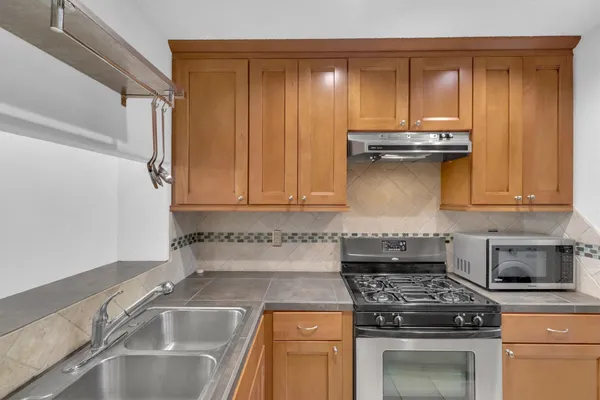 a kitchen with granite countertop a sink stove and cabinets