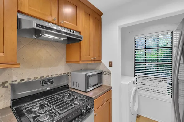 a kitchen with a stove a sink and cabinets