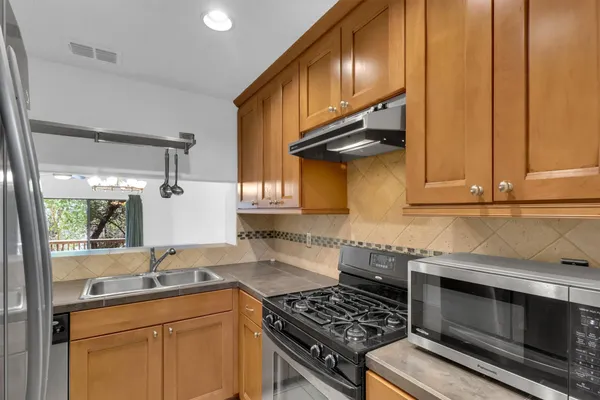 a kitchen with stainless steel appliances a stove a sink and a microwave