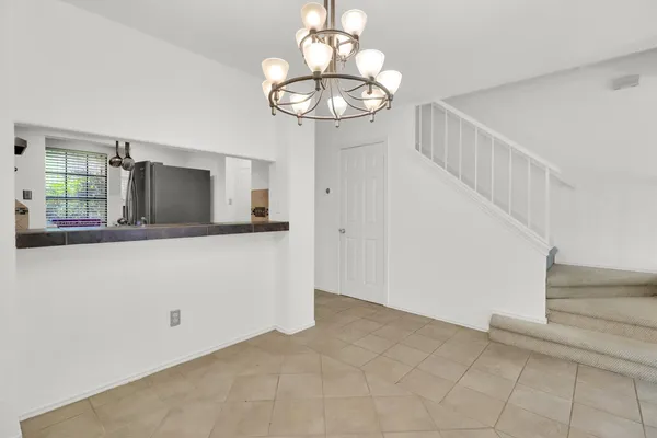 a view of a hallway with wooden floor and chandelier