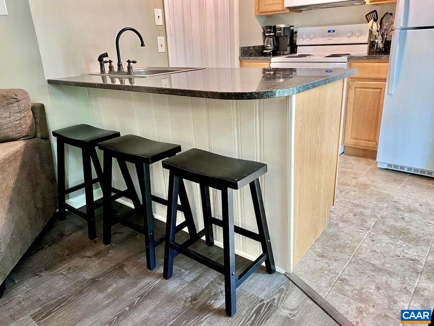 454 3 Ridges Wintergreen, VA 22967 - Photo 4 of 14 a kitchen with stainless steel appliances granite countertop a table chairs in it and wooden floors