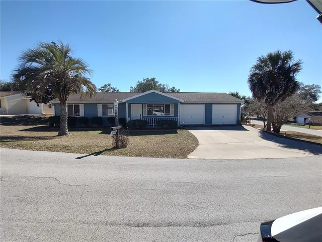 a view of a house with a yard and large trees