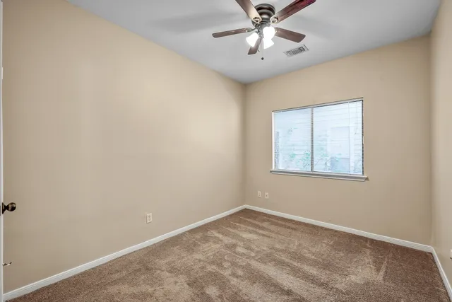 an empty room with a chandelier fan