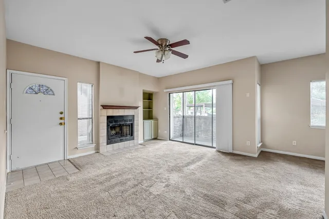 a view of an empty room with a fireplace and a window