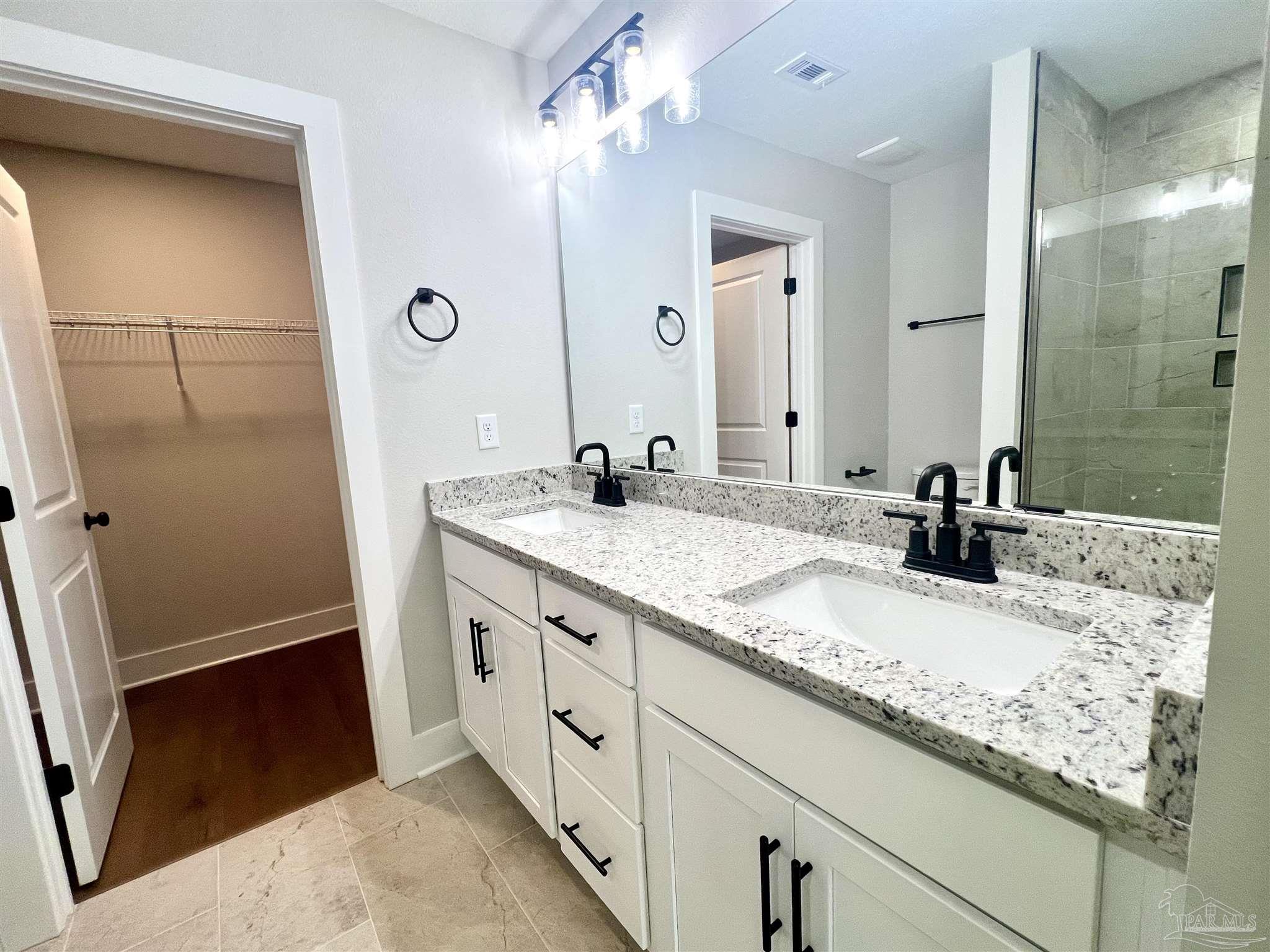 4417 Oak Lane Milton, FL 32583 - Photo 17 of 24 a bathroom with a sink double vanity and a mirror
