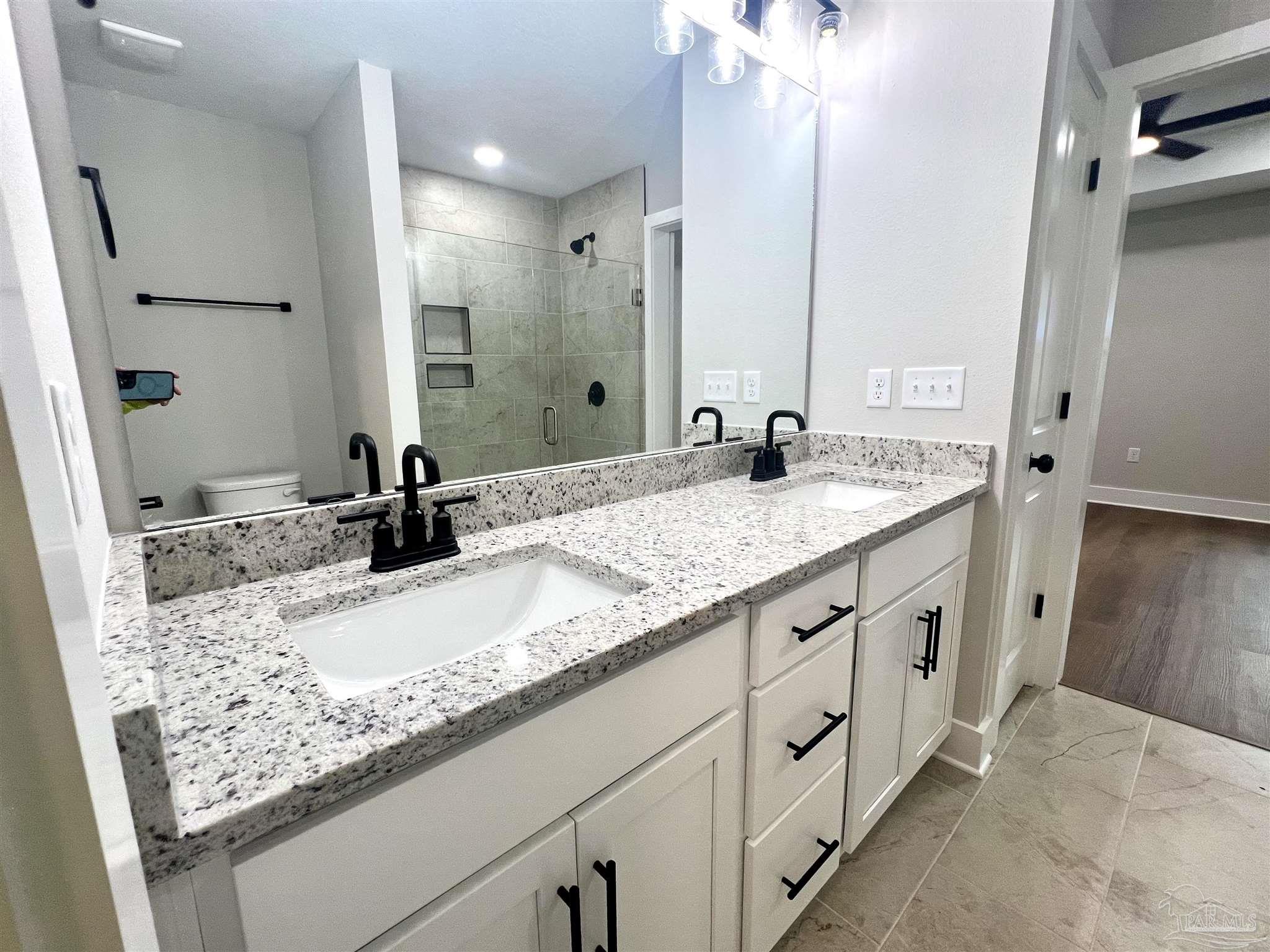 4417 Oak Lane Milton, FL 32583 - Photo 23 of 24 a bathroom with a granite countertop sink and a mirror