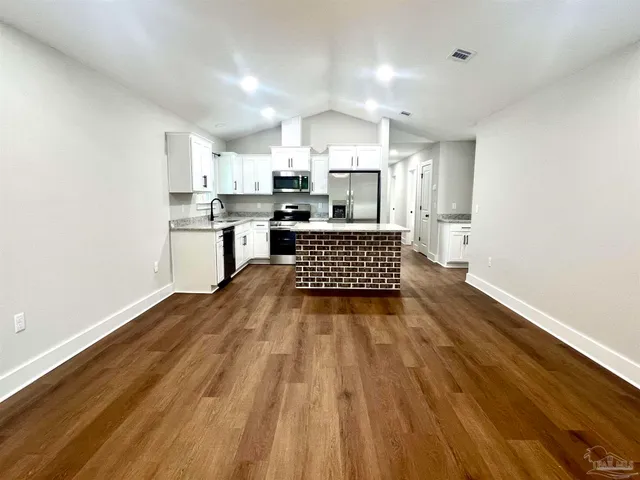 a kitchen with stainless steel appliances a refrigerator and a stove top oven