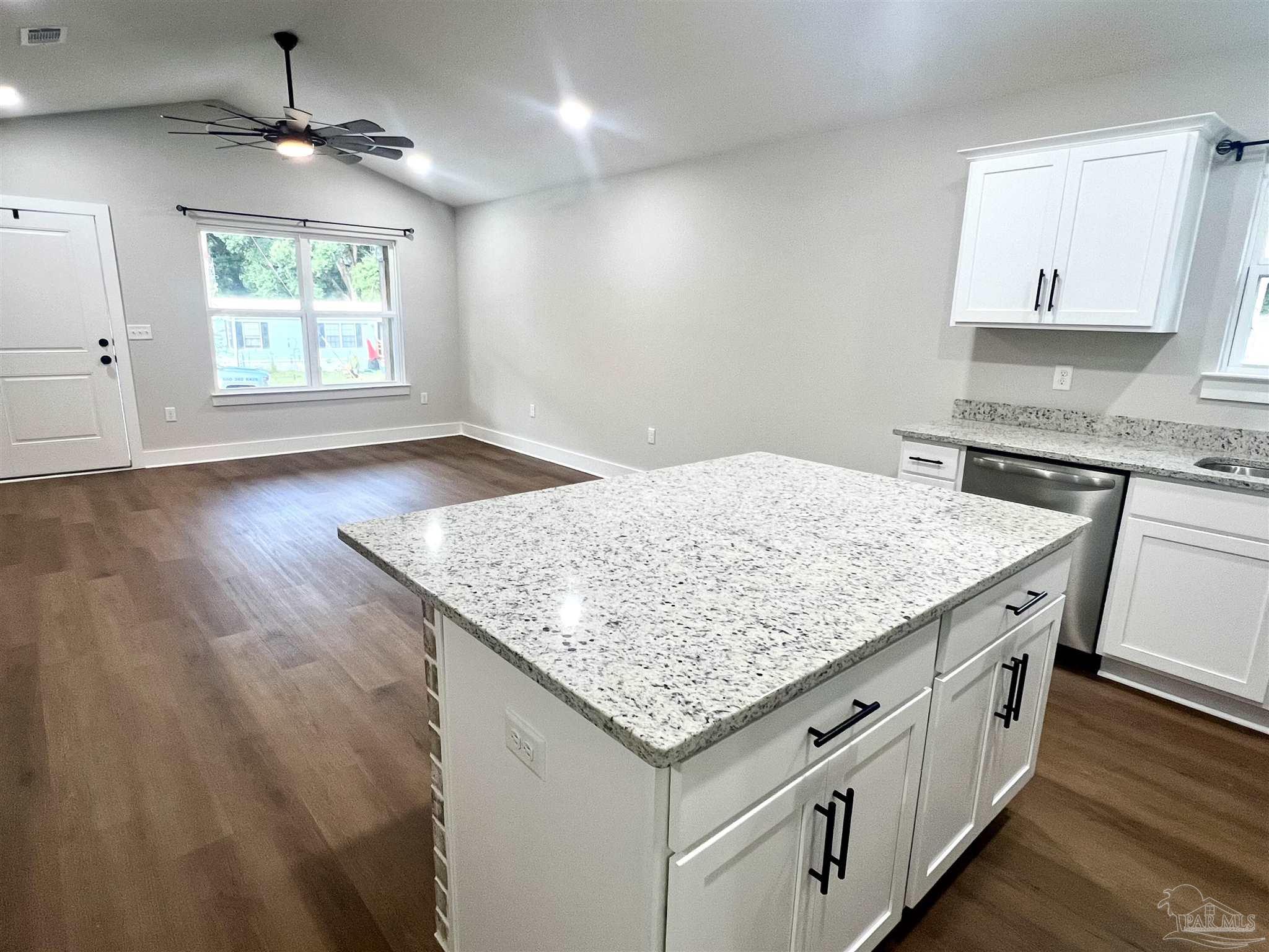 4417 Oak Lane Milton, FL 32583 - Photo 5 of 24 an open kitchen with granite countertop white cabinets and a wooden floor