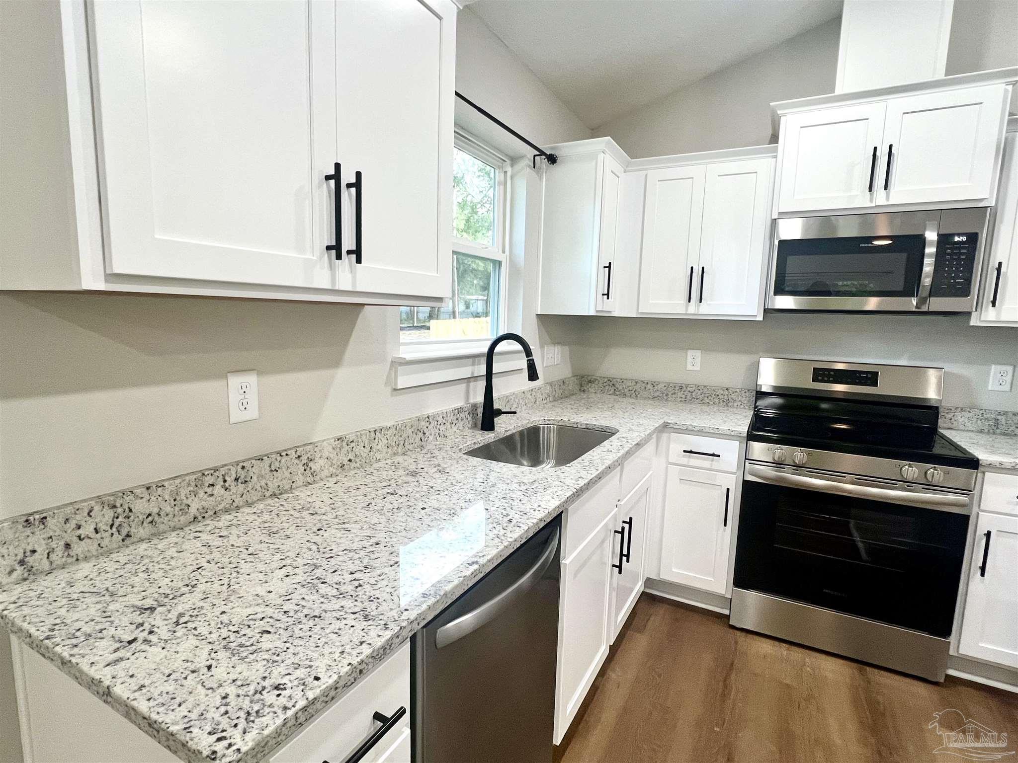 4417 Oak Lane Milton, FL 32583 - Photo 6 of 24 a kitchen with stainless steel appliances granite countertop a sink stove and microwave