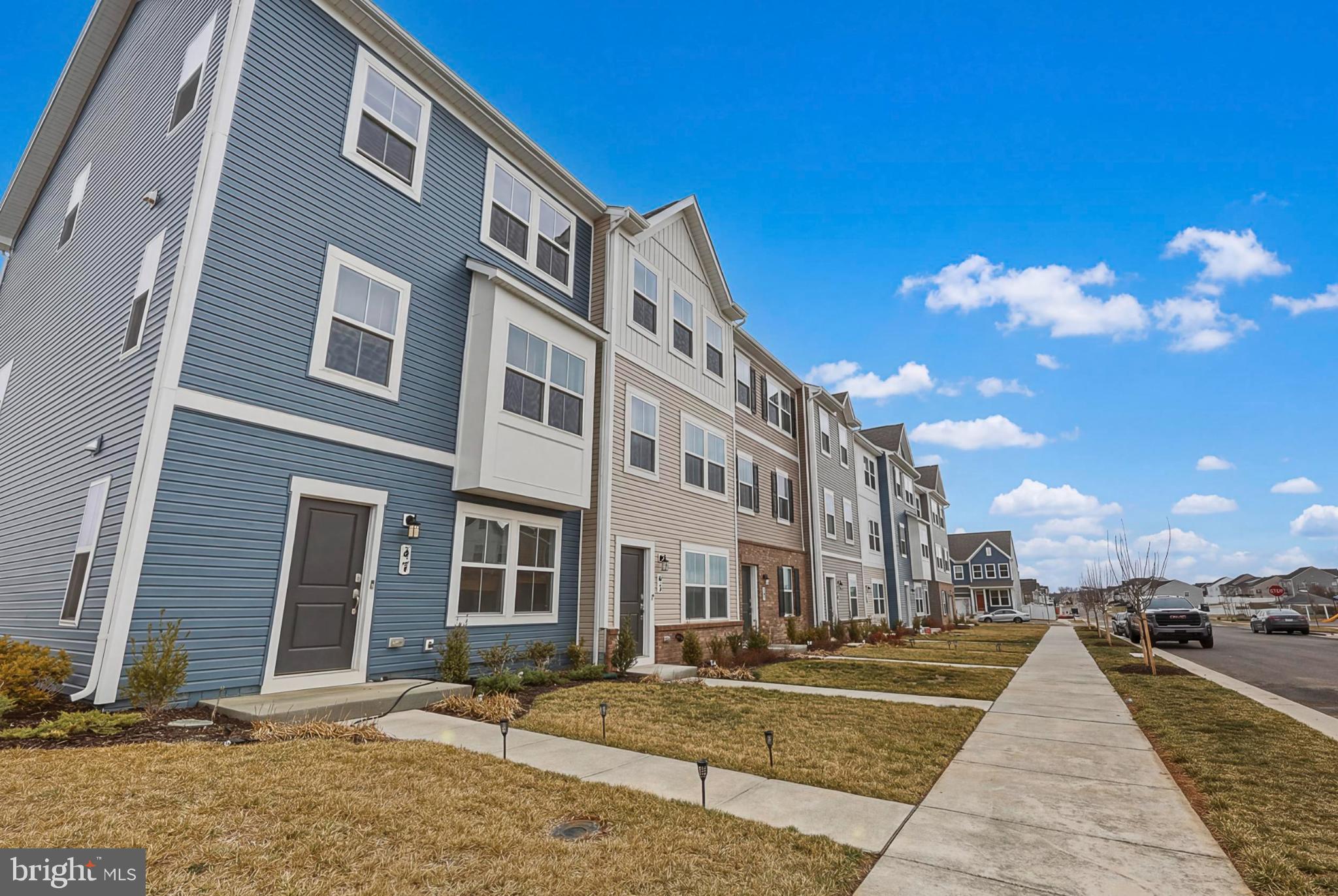 51 Short Br Drive Ranson, WV 25438 - Photo 4 of 30 Charming townhomes under a bright blue sky.