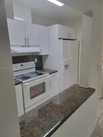 a kitchen with white cabinets and white appliances