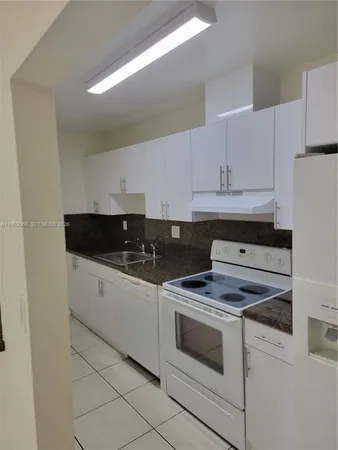 a view of kitchen with stove top oven and cabinets