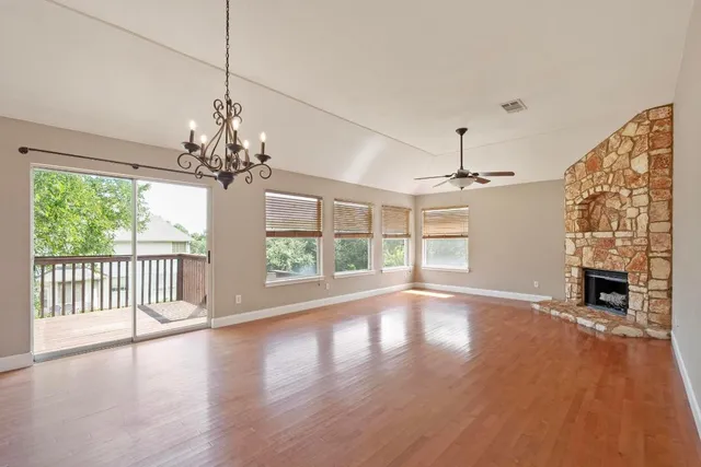 a view of a livingroom with wooden floor fireplace and a window