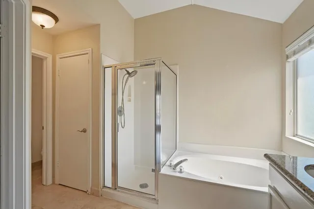 a bathroom with a granite countertop sink mirror and a bathtub