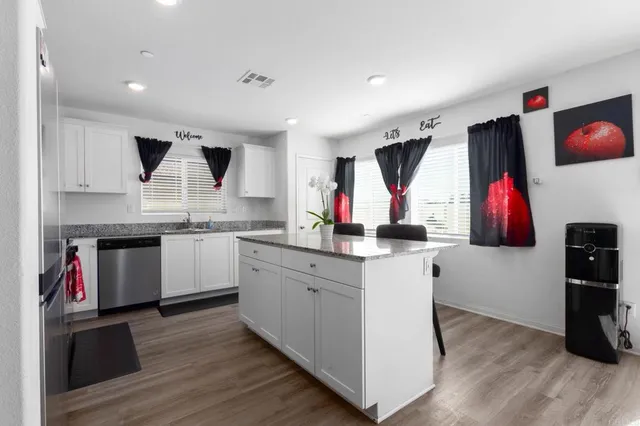 a kitchen with stainless steel appliances kitchen island wooden cabinets a stove and a sink