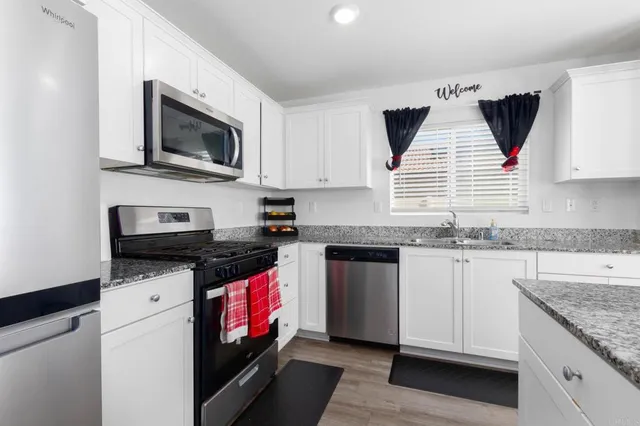 a kitchen with stainless steel appliances granite countertop a sink and a stove