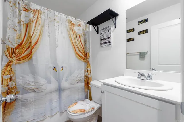a bathroom with a sink a toilet and shower curtain