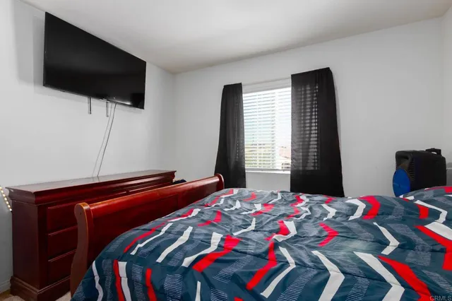 a bedroom with a bed and flat screen tv