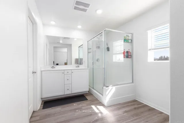 a bathroom with a shower sink and mirror