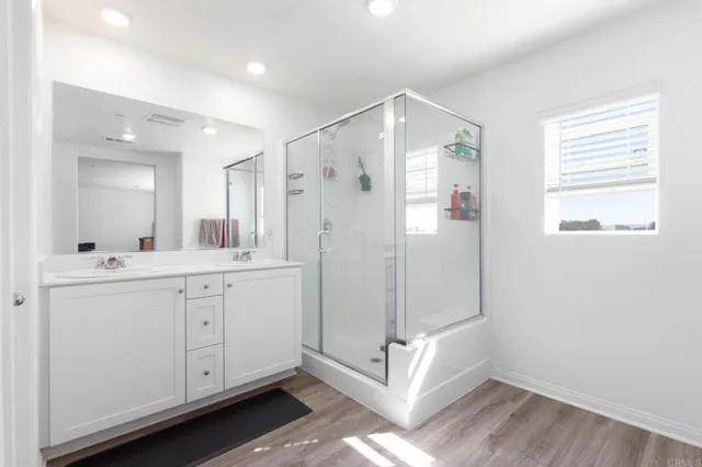 a bathroom with a shower sink and mirror