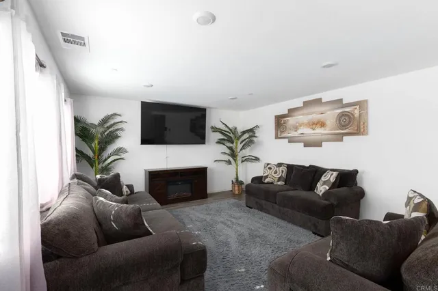 a living room with furniture a fireplace and a flat screen tv