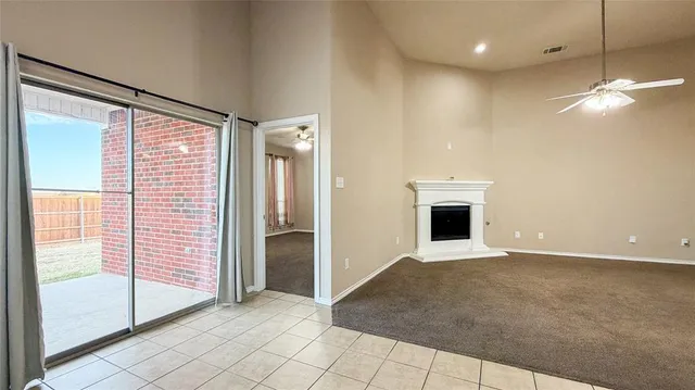 a view of an empty room with a fireplace and a glass door
