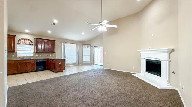 a large kitchen with stainless steel appliances granite countertop a stove a sink a refrigerator and a fireplace