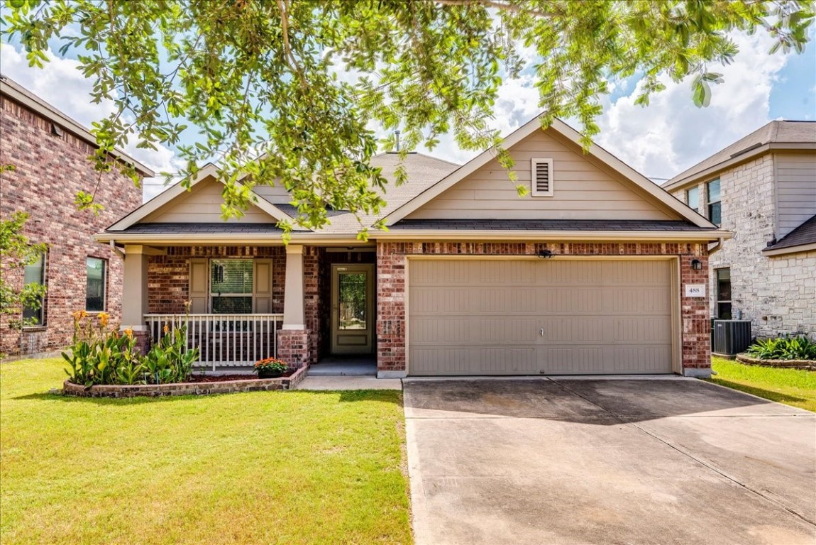 a front view of a house with a yard and potted plants