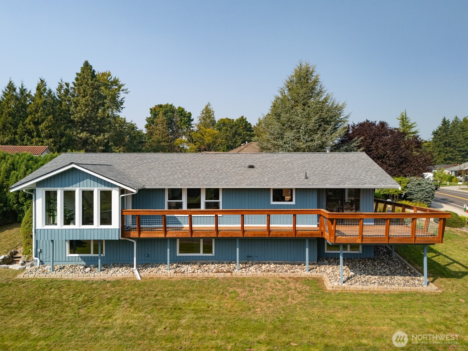 403 17th Street Lynden, WA 98264 - Photo 30 of 40 a white house with a large pool lawn chairs and a small yard