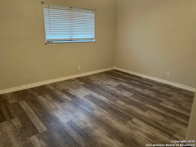 a view of a room with wooden floor and a window