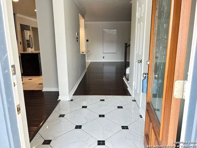a view of a hallway with wooden floor and staircase