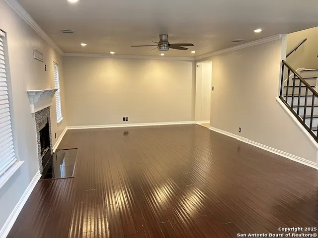 an empty room with wooden floor and a fireplace