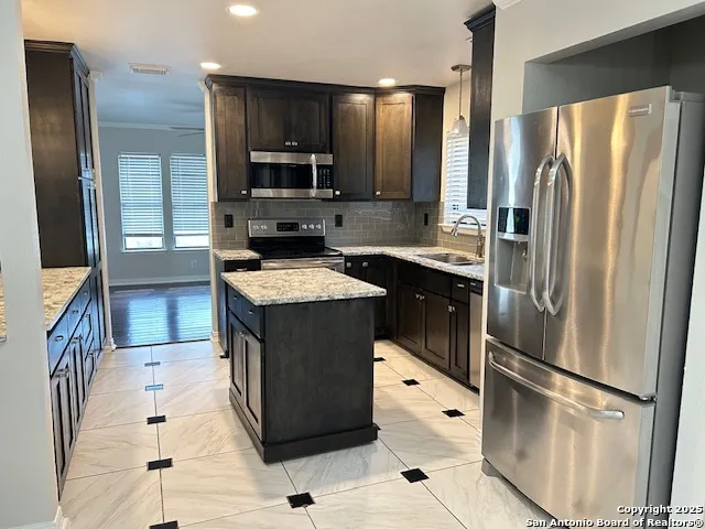 a kitchen with stainless steel appliances a refrigerator sink and microwave