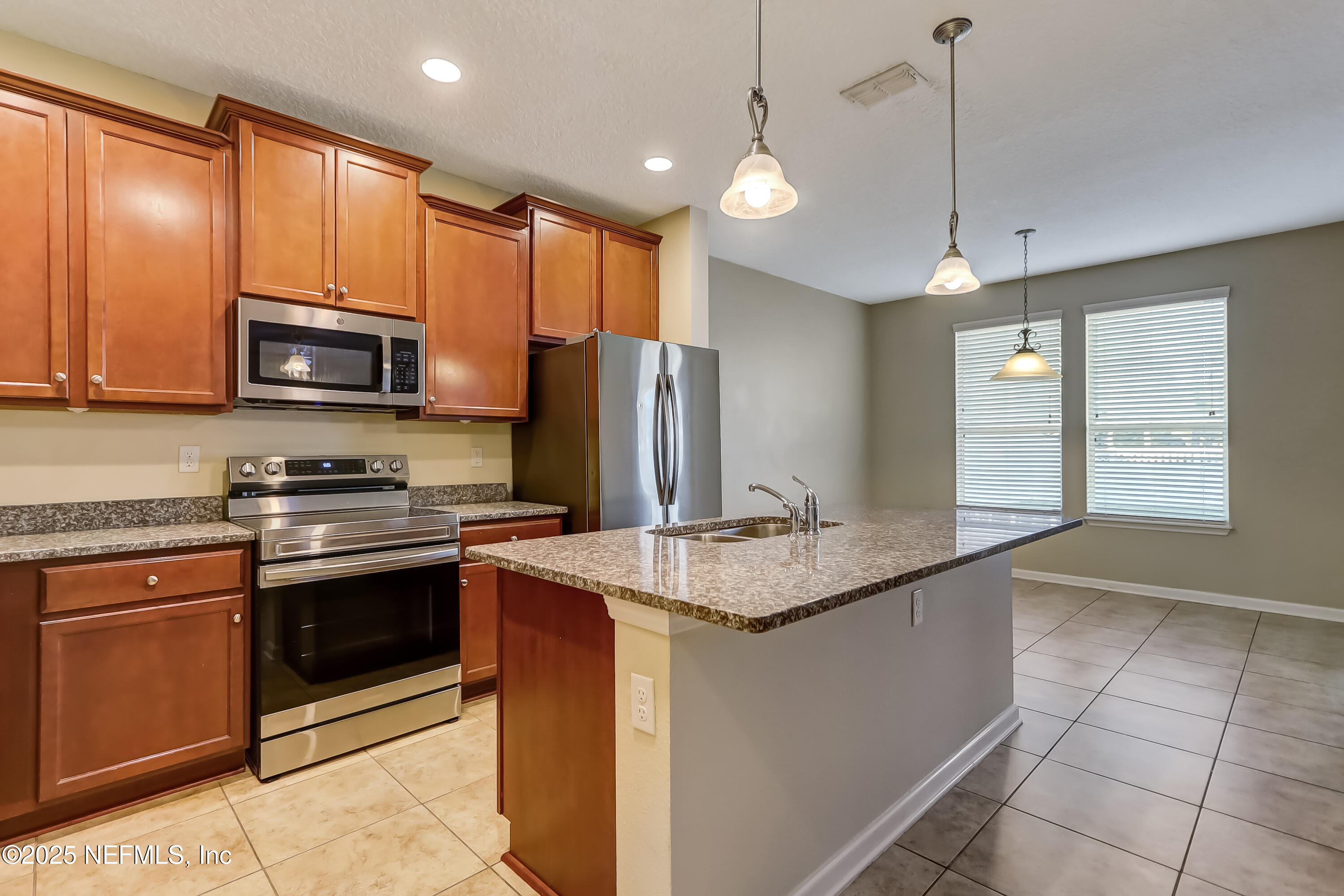 3838 Chasing Falls Road Orange Park, FL 32065 - Photo 7 of 36 a kitchen with stainless steel appliances granite countertop a stove refrigerator sink and microwave