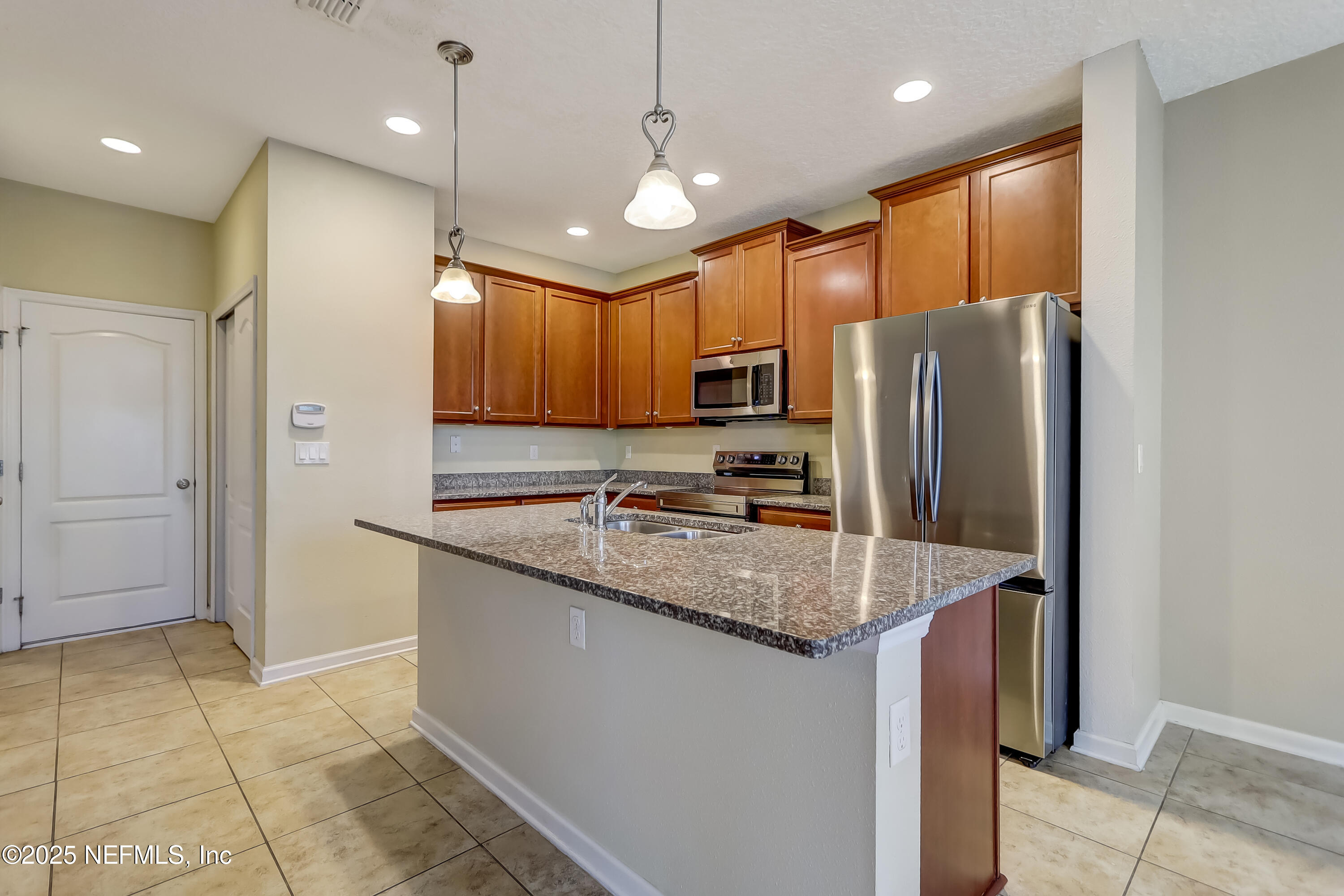 3838 Chasing Falls Road Orange Park, FL 32065 - Photo 9 of 36 a kitchen with stainless steel appliances granite countertop a refrigerator a sink a stove a microwave and island