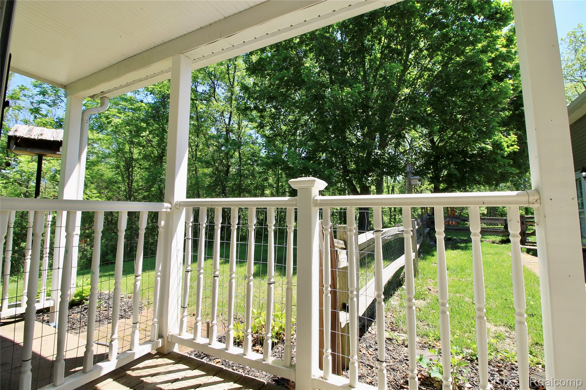8372 Parshallville Road Fenton, MI 48430 - Photo 18 of 44 Covered front porch featuring white railing, white columns, and a white ceiling