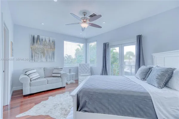 a spacious bedroom with a bed and wooden floor