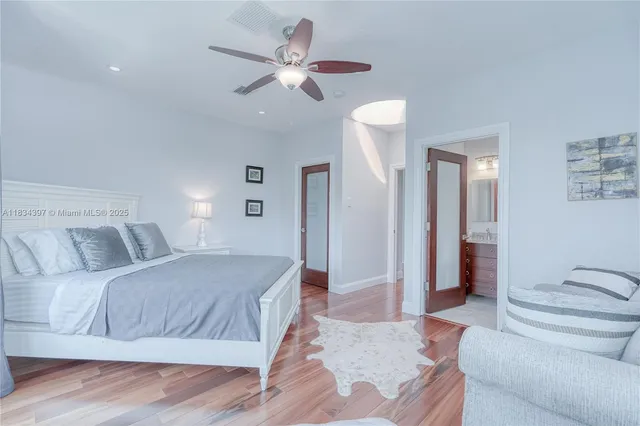 a spacious bedroom with a bed and wooden floor